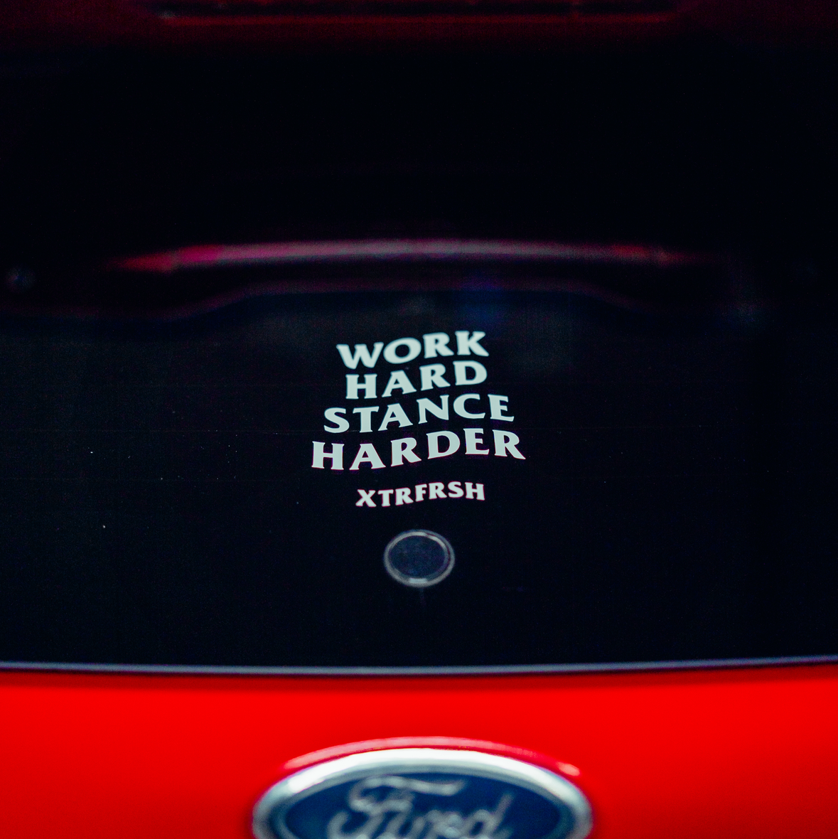 XTRFRSH Work/Stance sticker on a car window.
